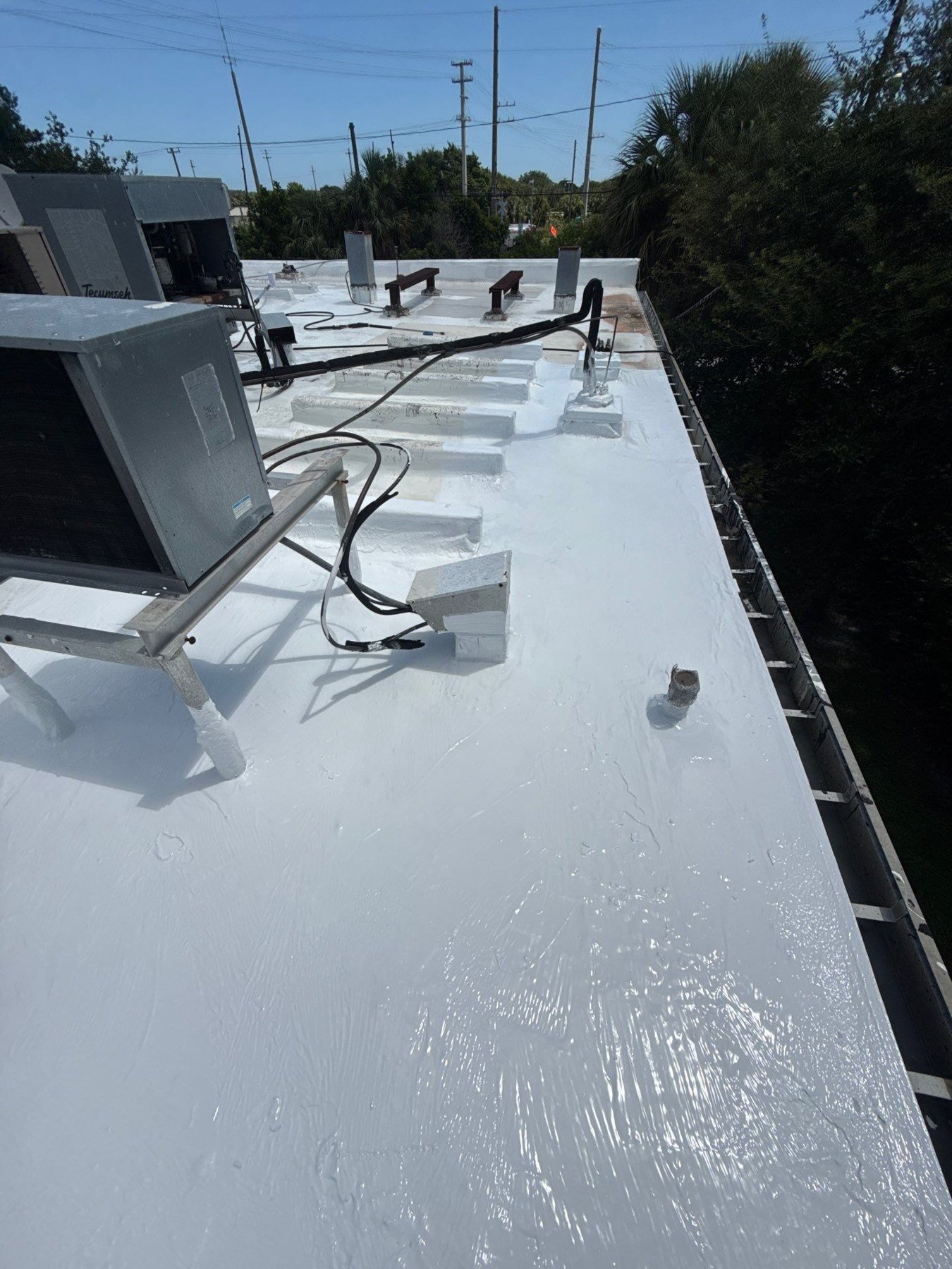 Commercial flat roof repair and coating work around rooftop equipment