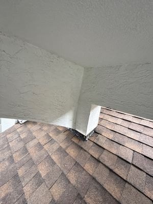 Finished shingles around the repaired roof transition in Lake Worth